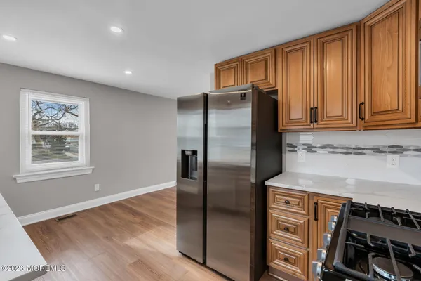 a kitchen with stainless steel appliances granite countertop a refrigerator and a stove top oven