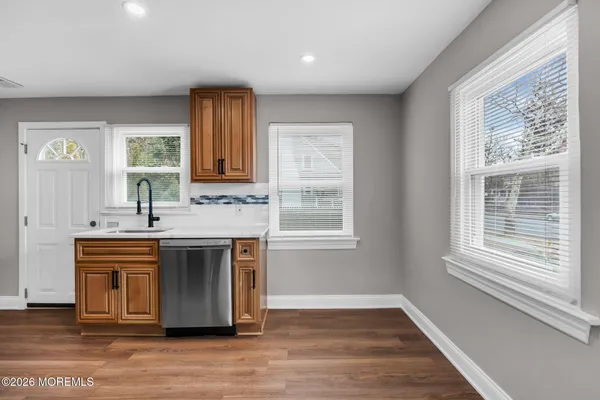 a view of cabinets a sink and a microwave in a room