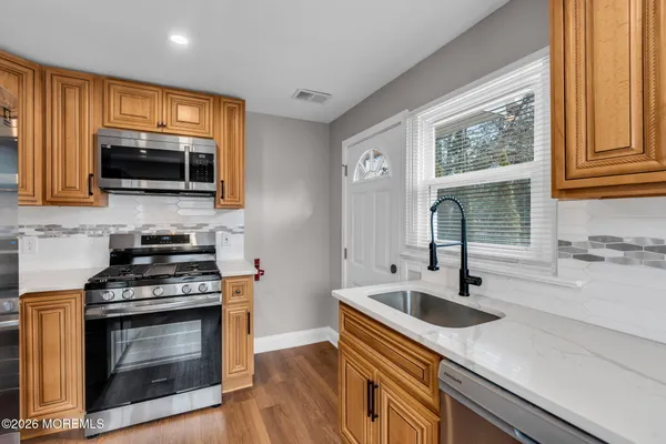 a kitchen with kitchen island a sink stainless steel appliances and cabinets