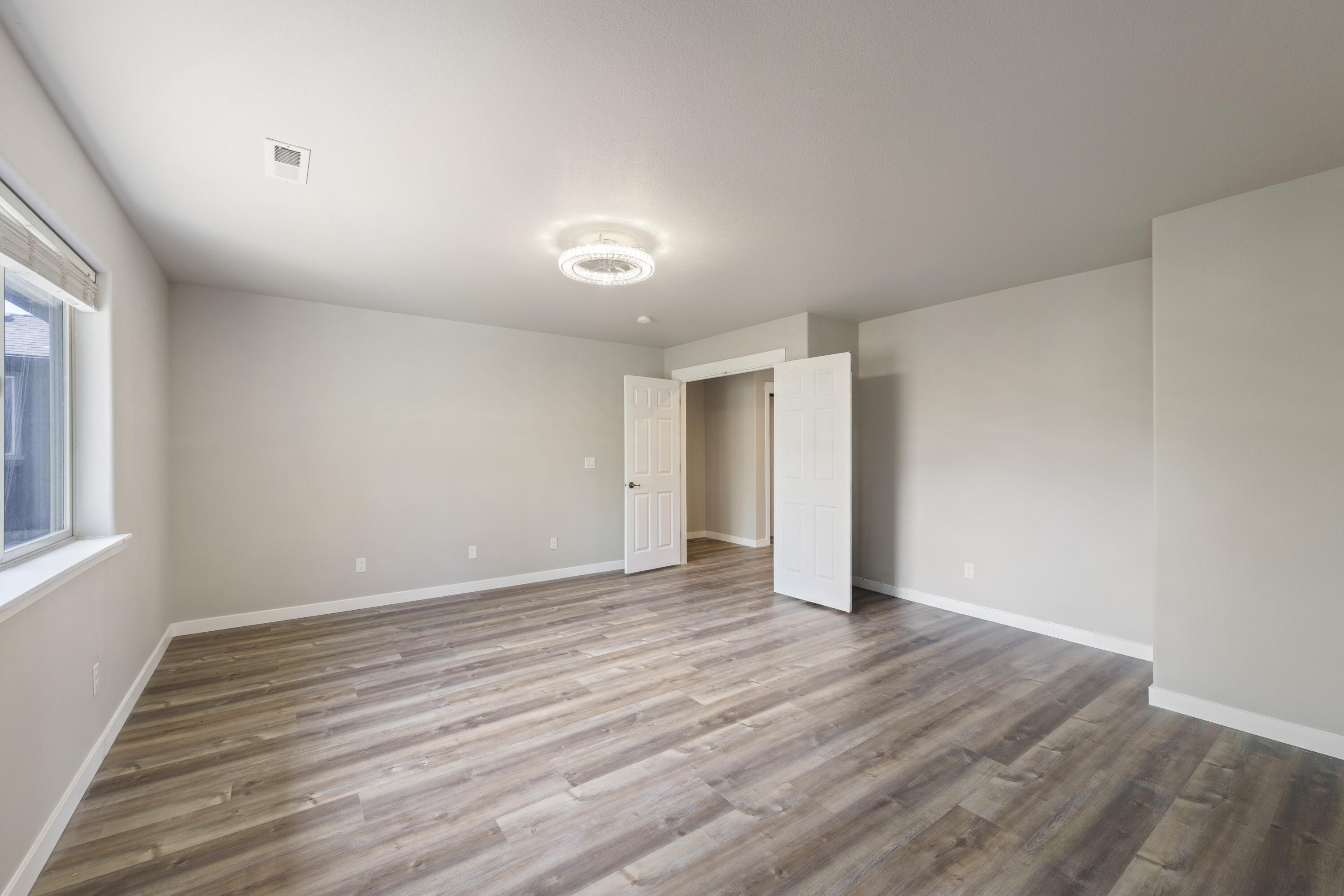 21189 Ritz Place Bend, OR 97702 - Photo 25 of 37 a view of an empty room with wooden floor and a window
