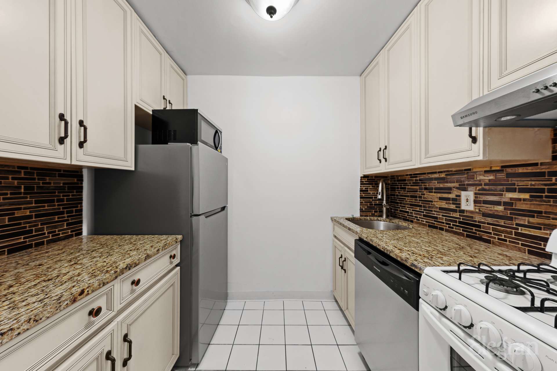 211 East 53rd Street, Unit 10F Manhattan, NY 10022 - Photo 5 of 8 a kitchen with granite countertop a stove and a refrigerator