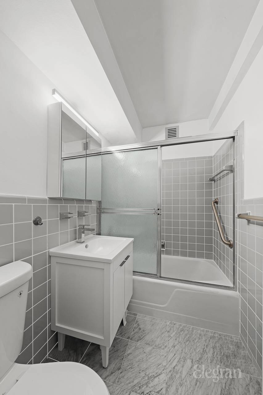211 East 53rd Street, Unit 10F Manhattan, NY 10022 - Photo 6 of 8 a bathroom with a sink toilet and shower