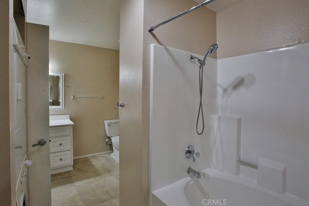 12635 Briarglen Loop, Unit G Stanton, CA 90680 - Photo 13 of 19 a bathroom with a tub shower vanity and a toilet