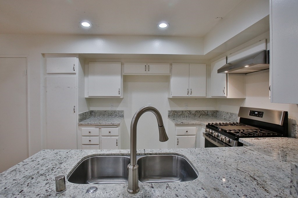 12635 Briarglen Loop, Unit G Stanton, CA 90680 - Photo 16 of 19 a kitchen with a sink a stove and a refrigerator
