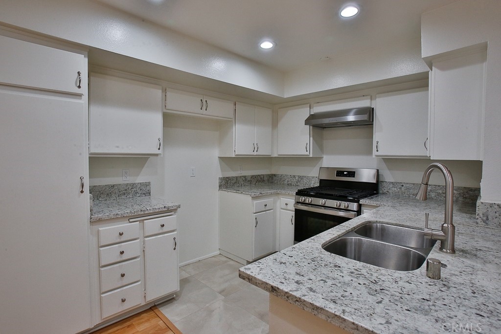 12635 Briarglen Loop, Unit G Stanton, CA 90680 - Photo 18 of 19 a kitchen with granite countertop a sink stainless steel appliances and cabinets