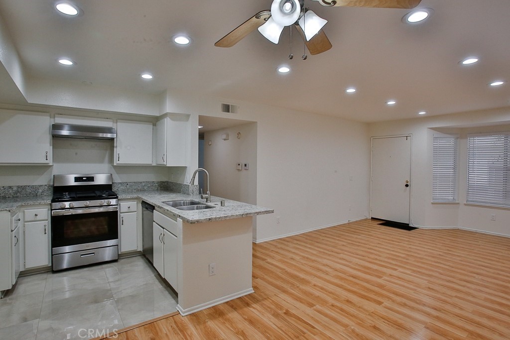 12635 Briarglen Loop, Unit G Stanton, CA 90680 - Photo 19 of 19 a kitchen with stainless steel appliances granite countertop a stove and a white cabinets