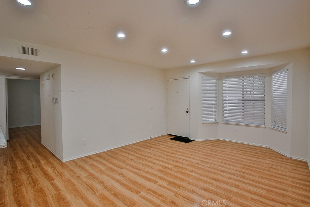 12635 Briarglen Loop, Unit G Stanton, CA 90680 - Photo 9 of 19 a view of an empty room with wooden floor and a window