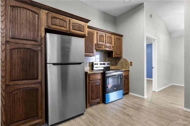 a kitchen with stainless steel appliances granite countertop a refrigerator stove and a sink