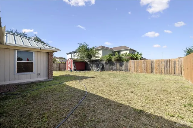 a view of a house with backyard and a tree