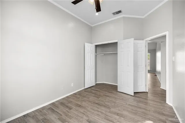 an empty room with a ceiling fan and entryway