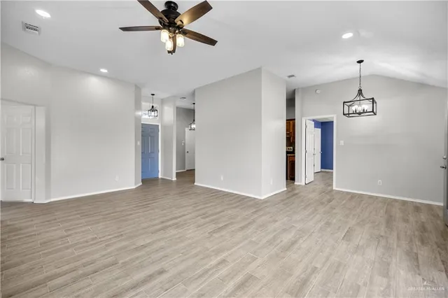 a view of empty room with wooden floor and ceiling fan