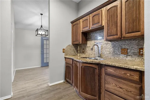 a kitchen with granite countertop a sink cabinets and wooden floor
