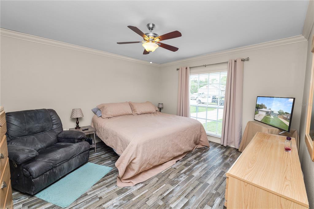 225 Lindale Street Lakeland, FL 33809 - Photo 19 of 37 a bedroom with a bed and wooden floor