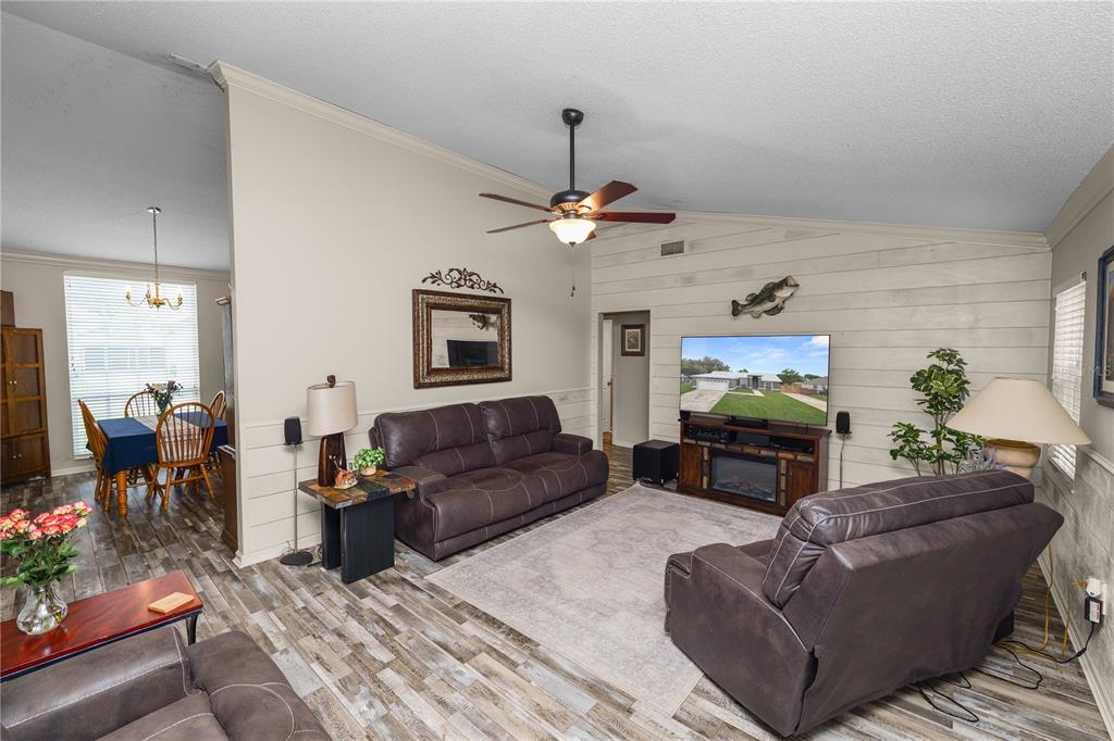 225 Lindale Street Lakeland, FL 33809 - Photo 6 of 37 a living room with furniture a chandelier and a fireplace