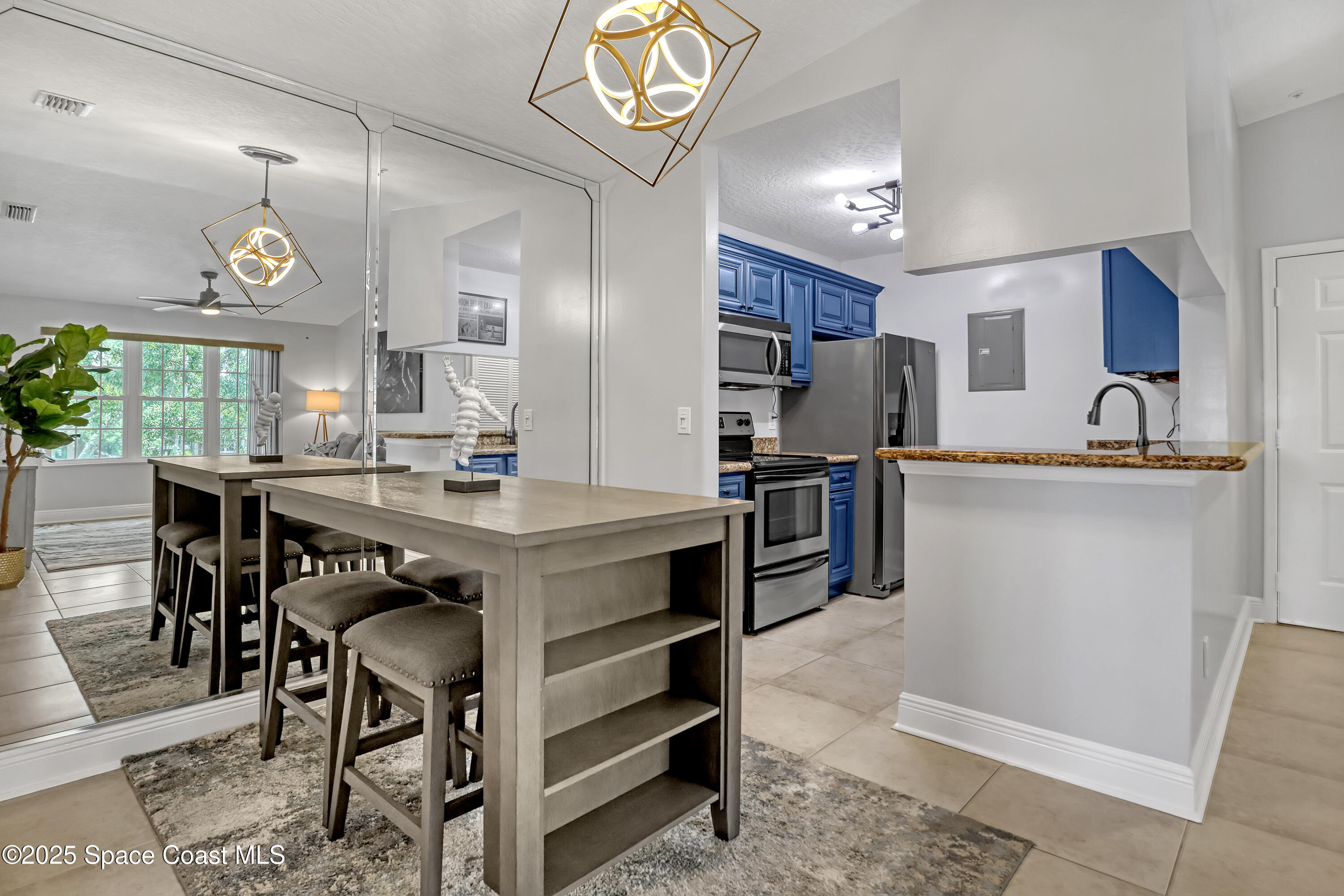 7667 North Wickham Road, Unit 224 Melbourne, FL 32940 - Photo 12 of 32 a kitchen with kitchen island granite countertop a sink cabinets a stove a refrigerator and a dining table