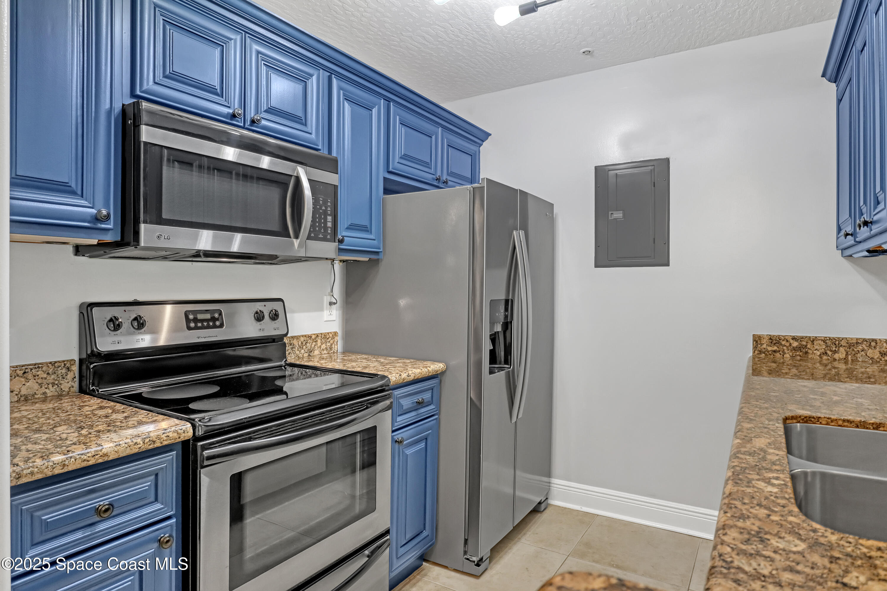 7667 North Wickham Road, Unit 224 Melbourne, FL 32940 - Photo 15 of 32 a kitchen with stainless steel appliances granite countertop a stove microwave and refrigerator