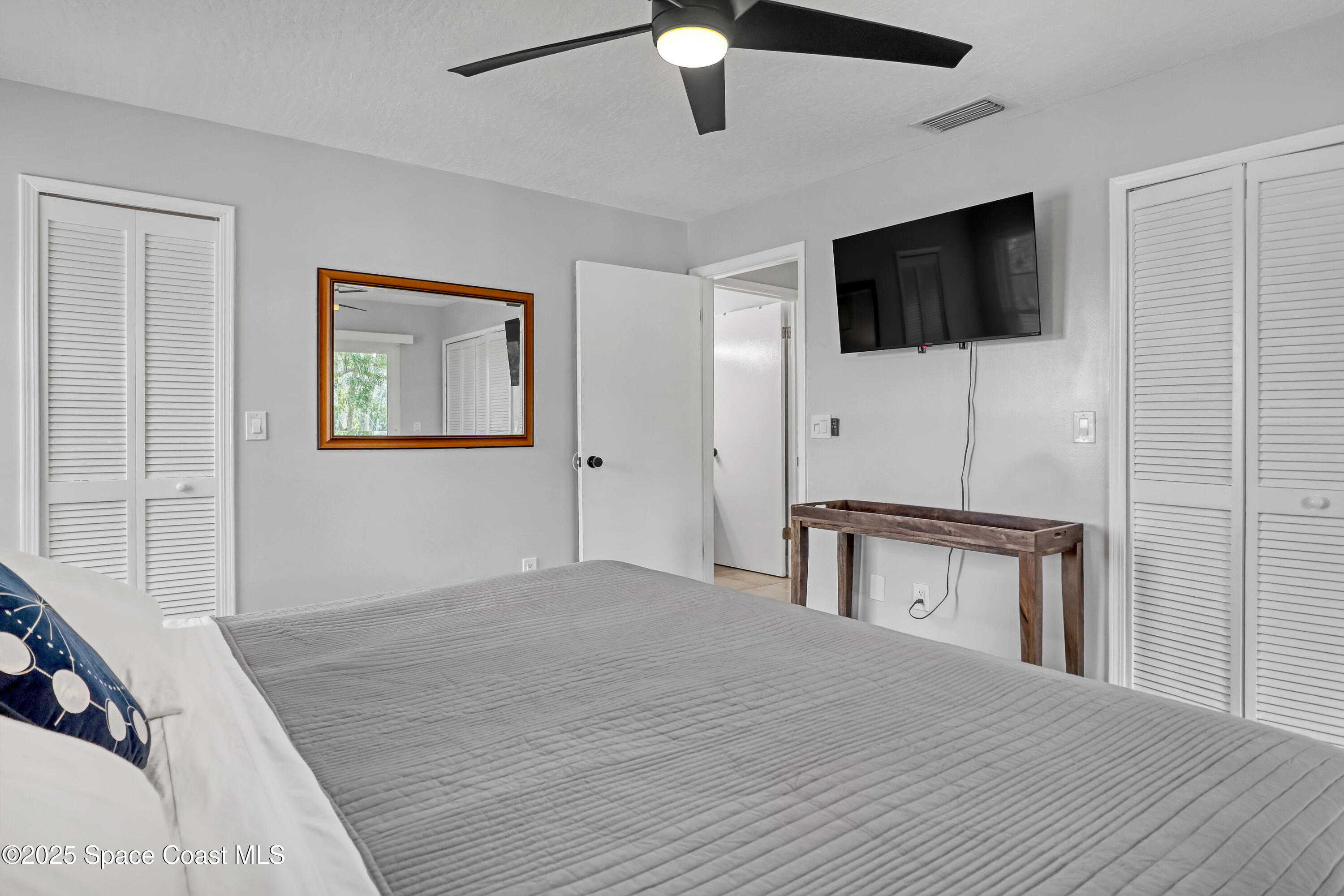 7667 North Wickham Road, Unit 224 Melbourne, FL 32940 - Photo 20 of 32 a bedroom with a bed and a flat screen tv