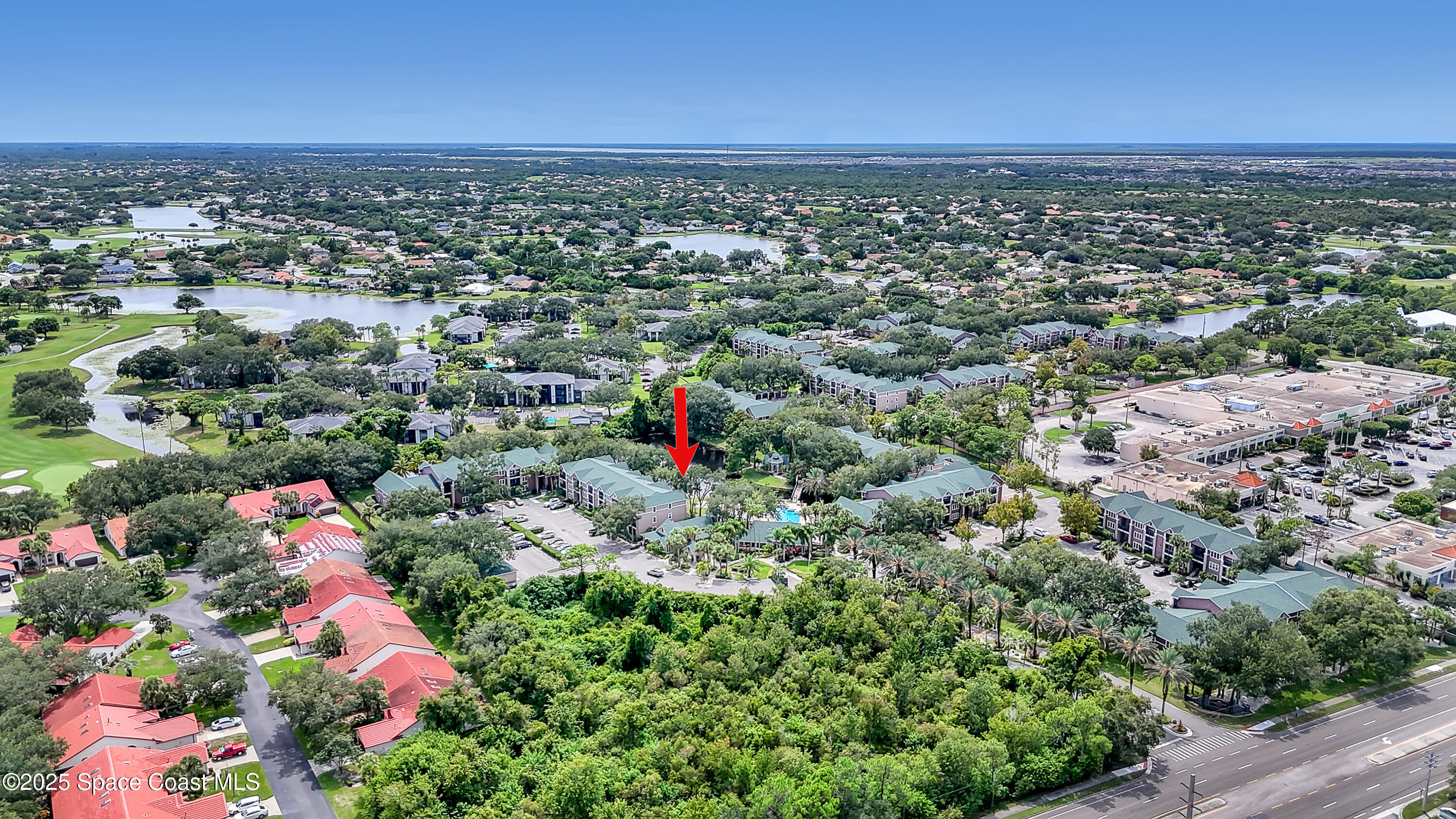 7667 North Wickham Road, Unit 224 Melbourne, FL 32940 - Photo 28 of 32 an aerial view of residential houses with outdoor space and trees