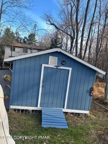 a view of a lake with lawn chairs and large trees