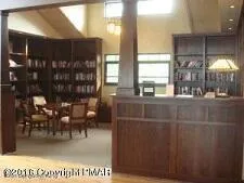 a view of a backyard with table and chairs potted plants and a large tree