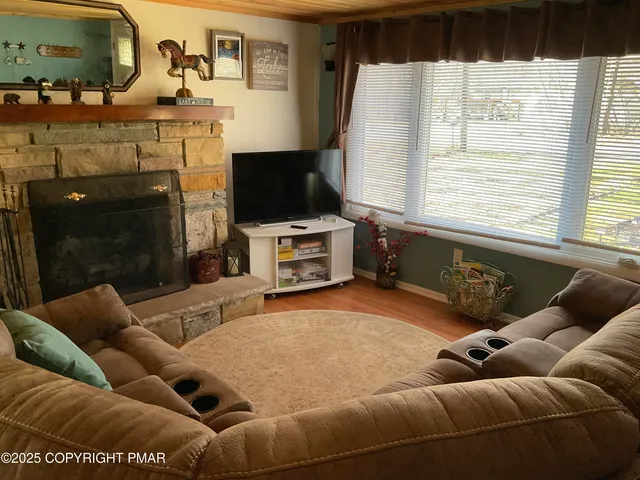 a living room with furniture a flat screen tv and a fireplace