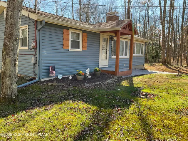 a view of a small house with yard and plants