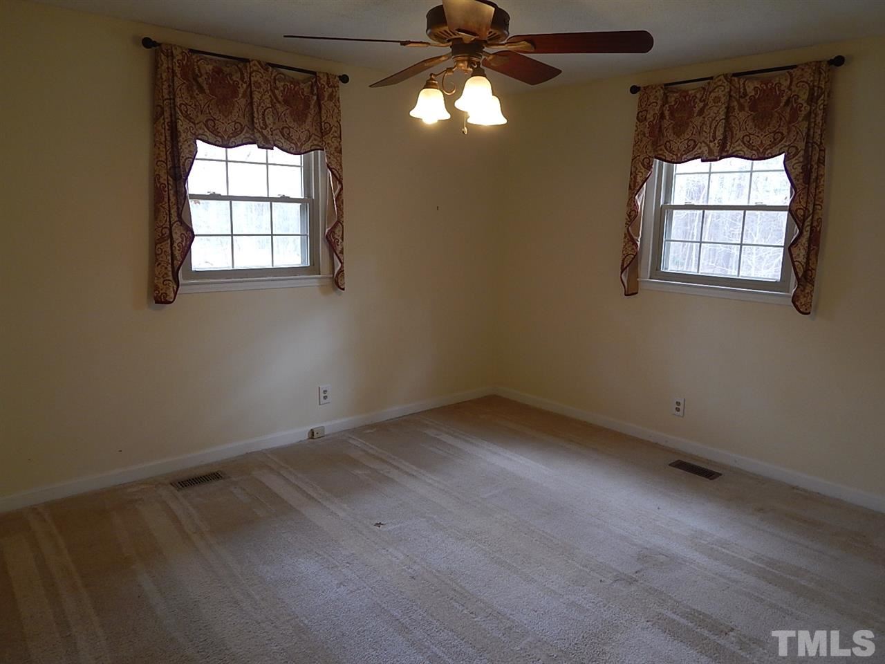1427 Torredge Road Durham, NC 27712 - Photo 11 of 17 an empty room with windows and chandelier fan