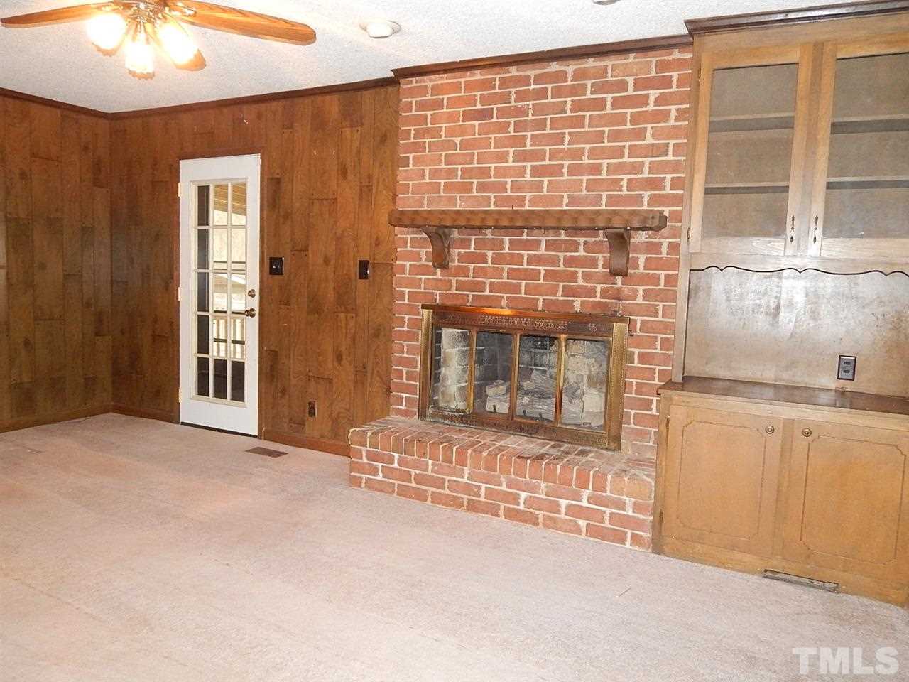 1427 Torredge Road Durham, NC 27712 - Photo 5 of 17 a view of an empty room with a fireplace and a window