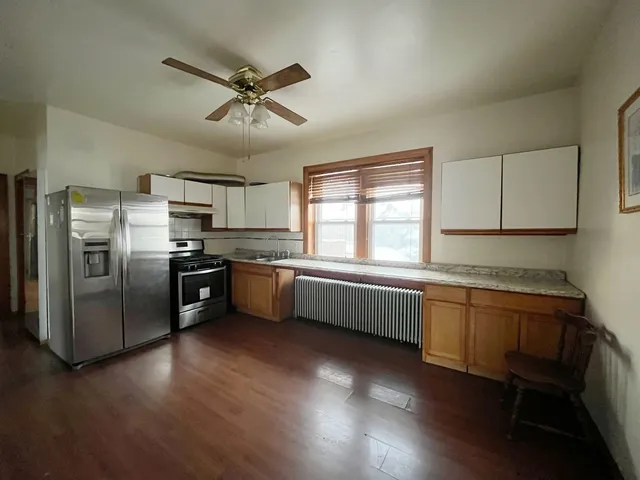 a kitchen with stainless steel appliances kitchen island granite countertop a refrigerator a sink dishwasher a stove and a microwave oven with cabinets