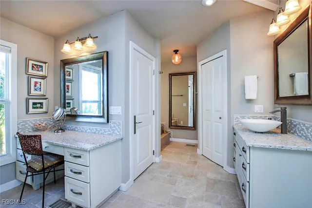 a spacious bathroom with a granite countertop sink a mirror and a vanity