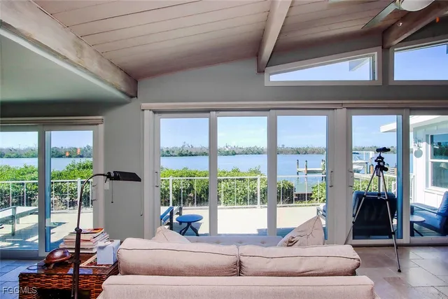 a living room with furniture and floor to ceiling windows