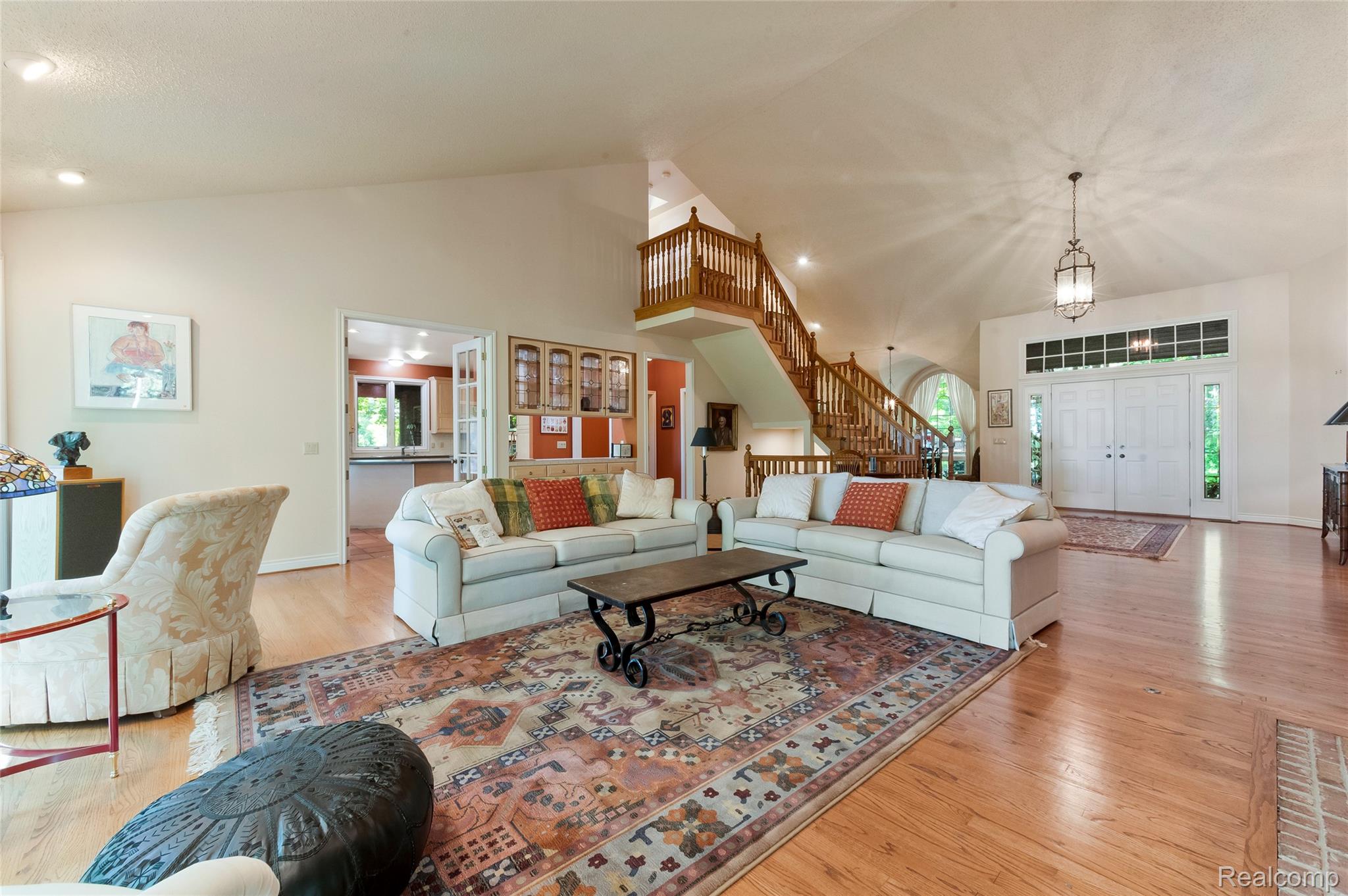 2323 Addaleen Road Highland, MI 48357 - Photo 32 of 70 Expansive living area featuring vaulted ceilings, wood-finish flooring and a grand staircase