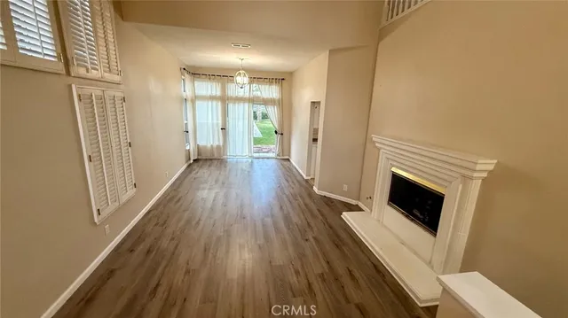 a view of a livingroom with wooden floor and a fireplace