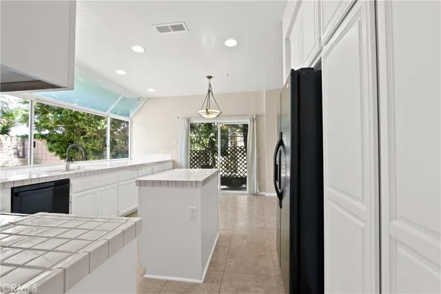 a kitchen with kitchen island sink stove and refrigerator