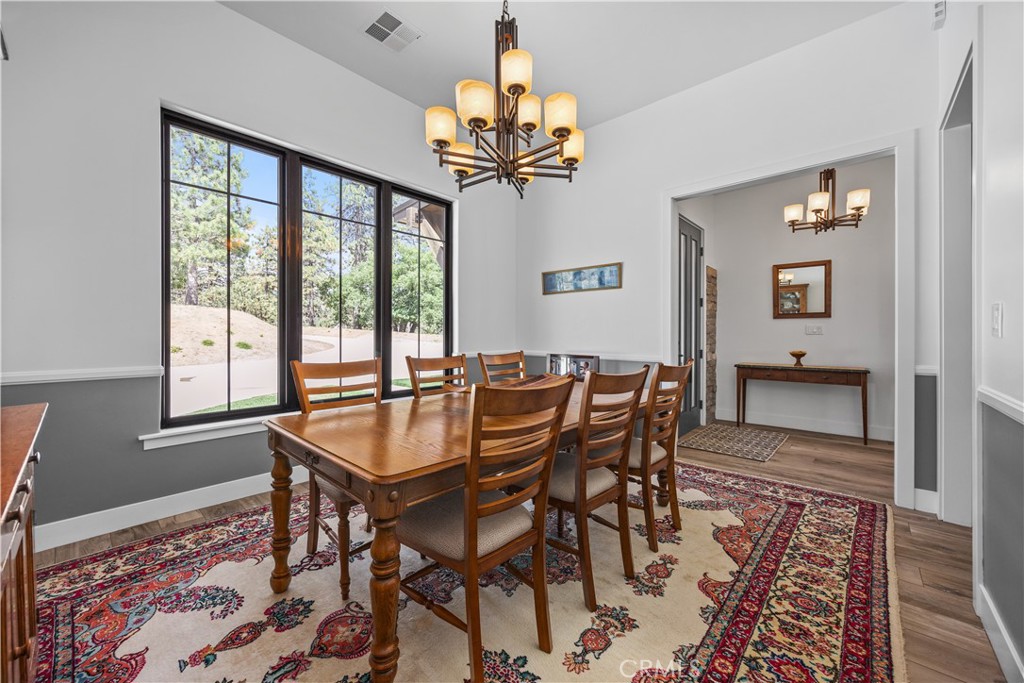 27300 Stirrup Way Tehachapi, CA 93561 - Photo 31 of 45 a dining room with chandelier and wooden floor