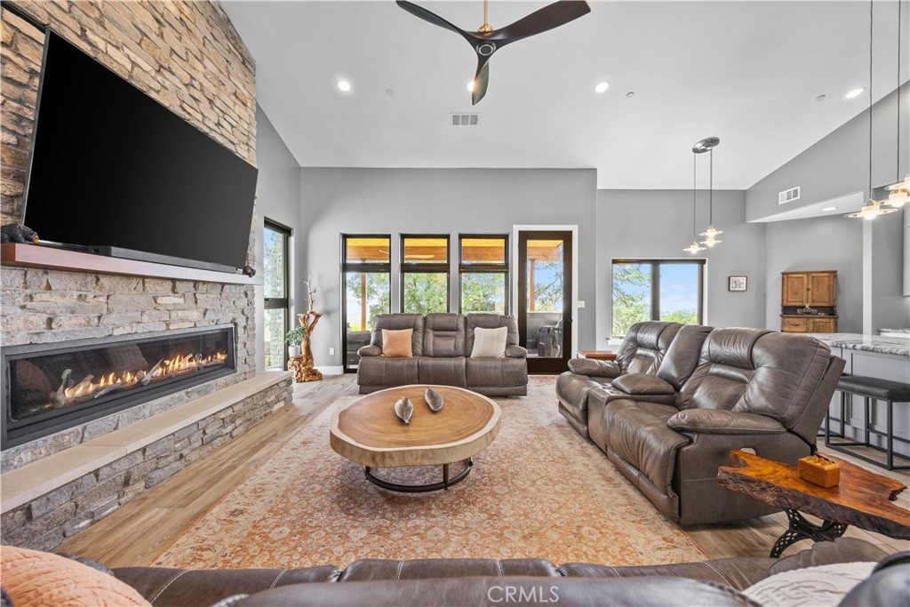 27300 Stirrup Way Tehachapi, CA 93561 - Photo 32 of 45 a living room with furniture a flat screen tv and a fireplace