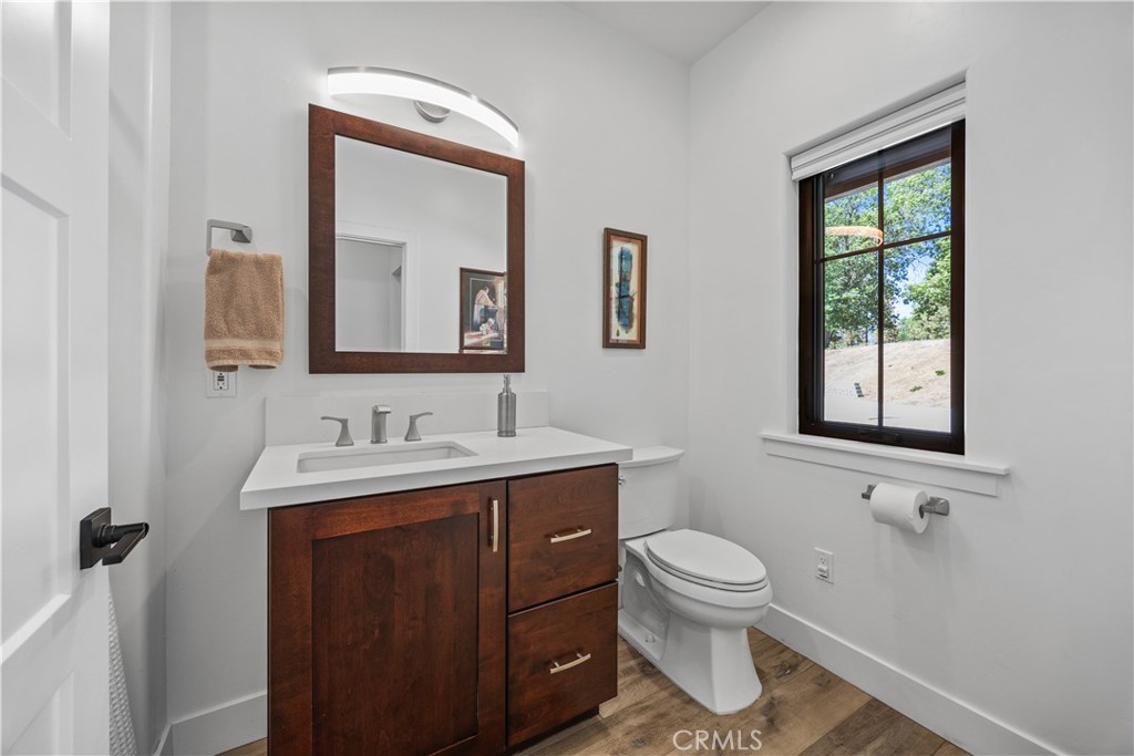 27300 Stirrup Way Tehachapi, CA 93561 - Photo 36 of 45 a bathroom with a toilet a sink a vanity a mirror and a window