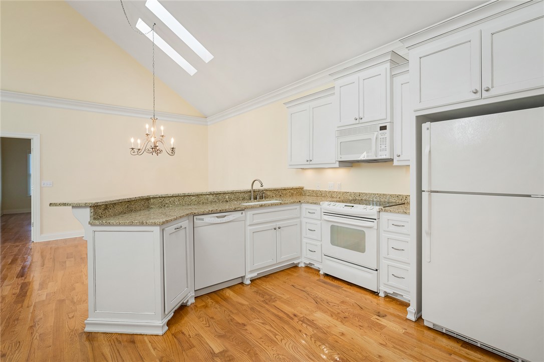 16 Oleander Drive Anderson, SC 29621 - Photo 12 of 37 Culinary aspirations find their home in this well-appointed kitchen featuring granite countertops and hardwood flooring.