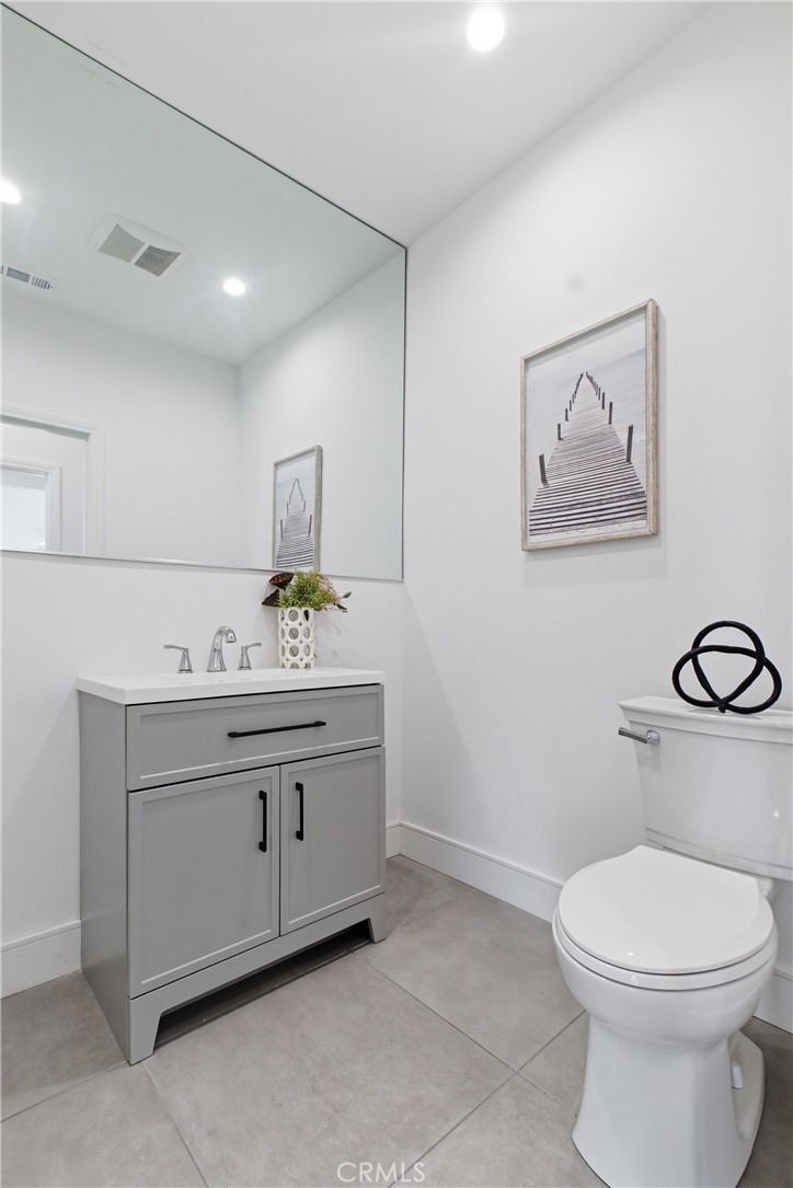 1364 Ridgeley Drive Los Angeles, CA 90019 - Photo 8 of 25 a bathroom with a toilet a sink and mirror
