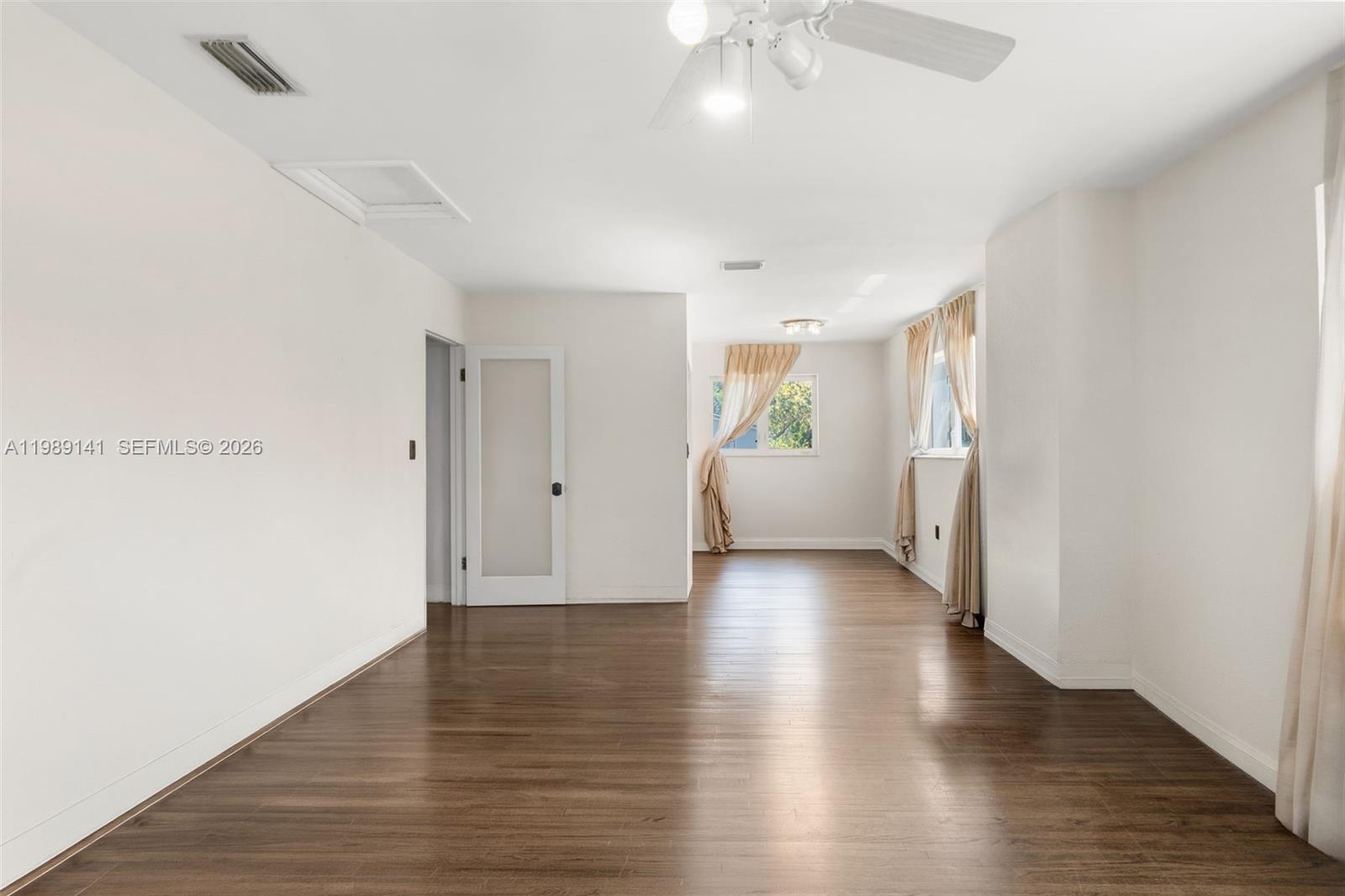 7390 Southwest 114th Street Pinecrest, FL 33156 - Photo 12 of 19 an empty room with wooden floor and windows