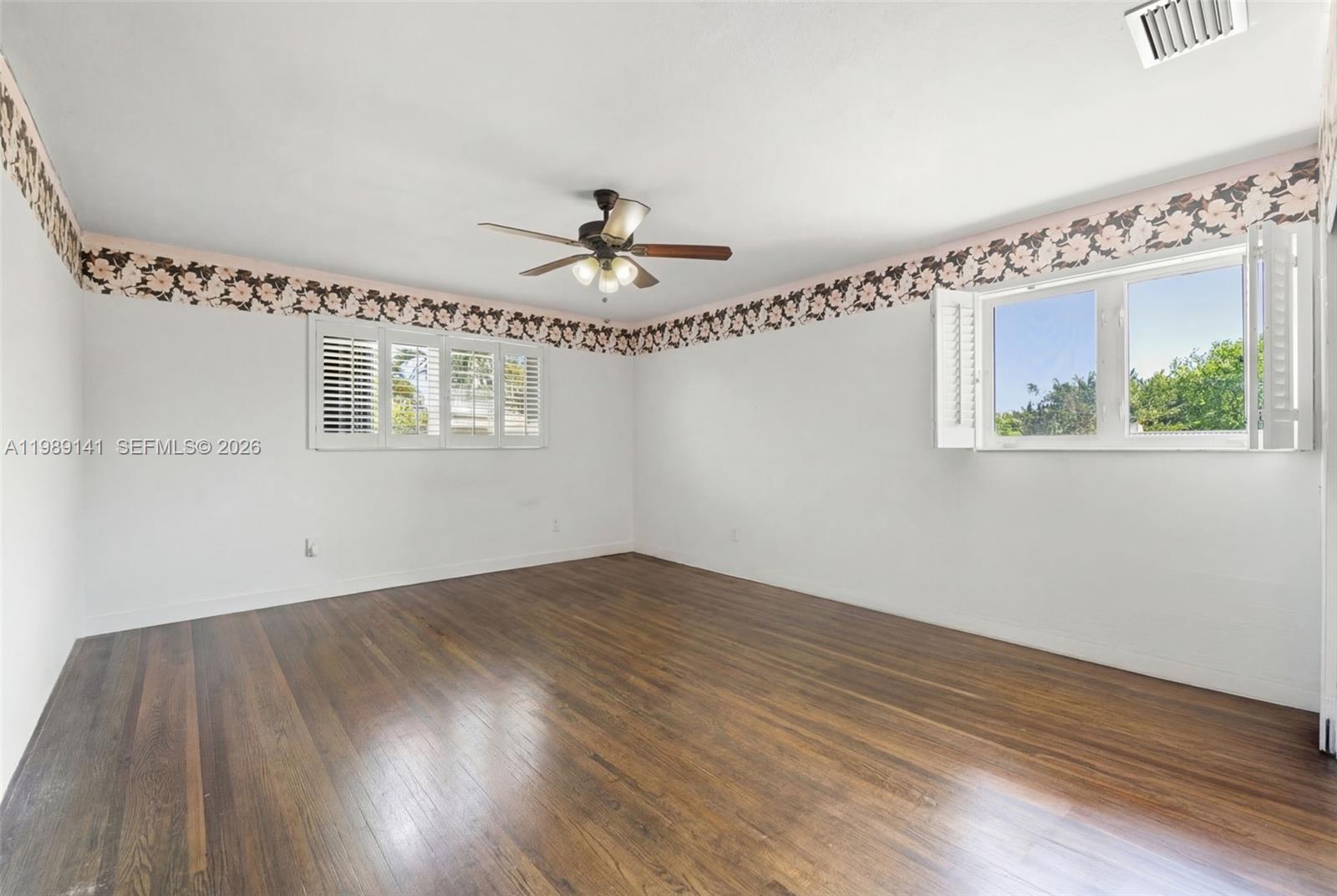 7390 Southwest 114th Street Pinecrest, FL 33156 - Photo 14 of 19 a view of an empty room with wooden floor and a window