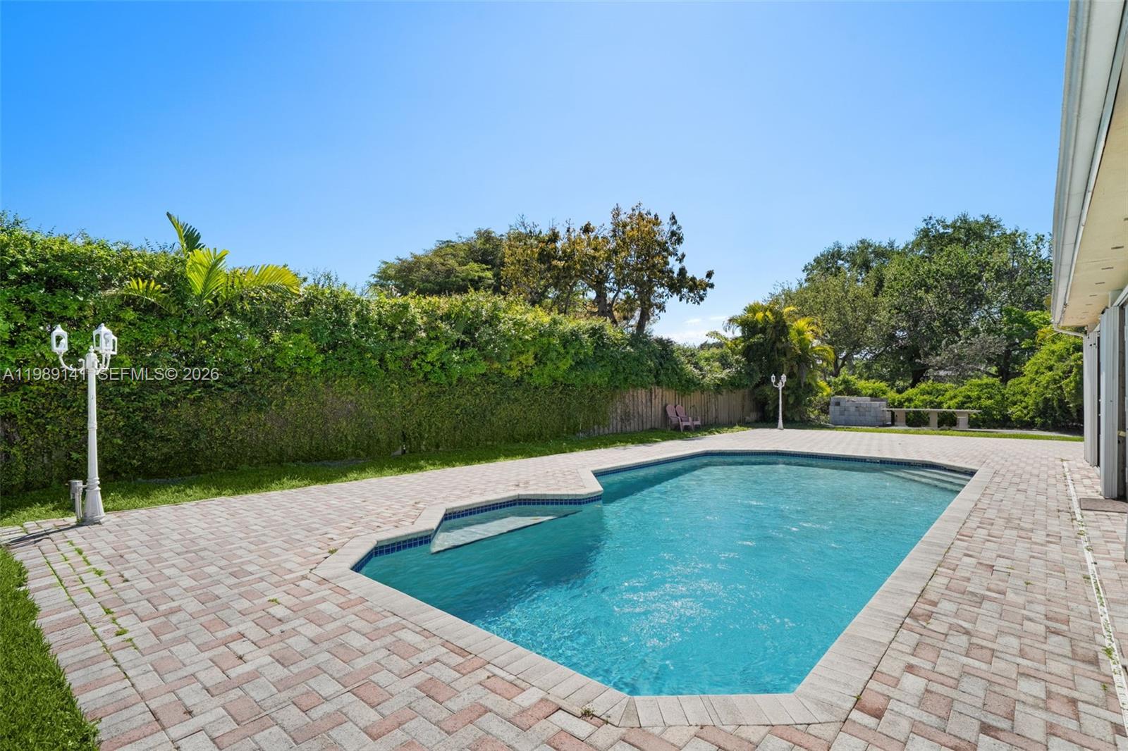7390 Southwest 114th Street Pinecrest, FL 33156 - Photo 18 of 19 a view of a swimming pool with a yard