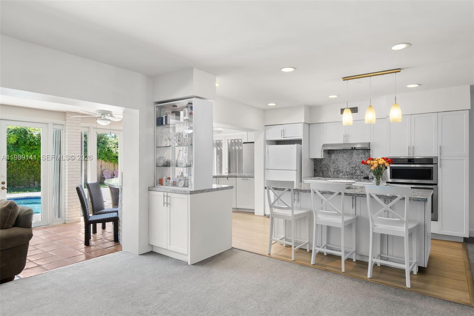 7390 Southwest 114th Street Pinecrest, FL 33156 - Photo 8 of 19 a kitchen with stainless steel appliances kitchen island granite countertop a table and chairs