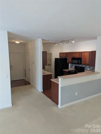a living room with stainless steel appliances kitchen island a refrigerator and a stove top oven
