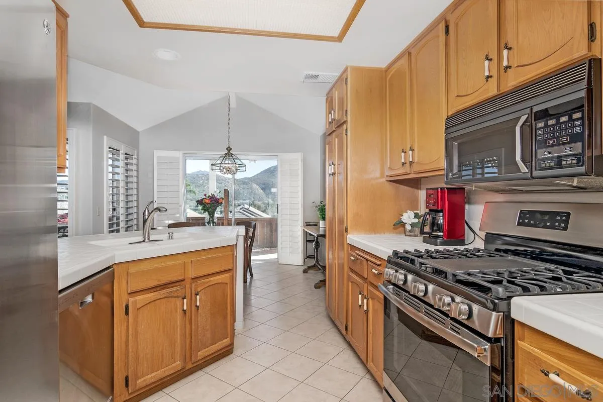 1237 Buttonwood Court El Cajon, CA 92019 - Photo 11 of 45 a kitchen with stainless steel appliances granite countertop a stove and a sink
