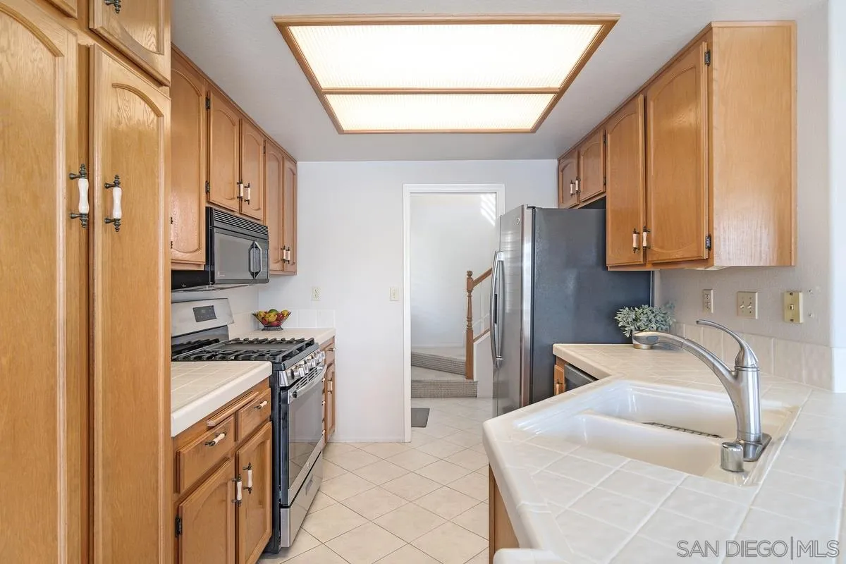 1237 Buttonwood Court El Cajon, CA 92019 - Photo 12 of 45 a kitchen with stainless steel appliances granite countertop a refrigerator a stove a sink and a microwave