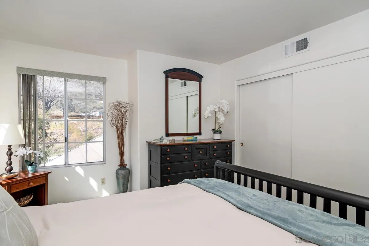 1237 Buttonwood Court El Cajon, CA 92019 - Photo 21 of 45 a bedroom with a bed a dresser and large windows