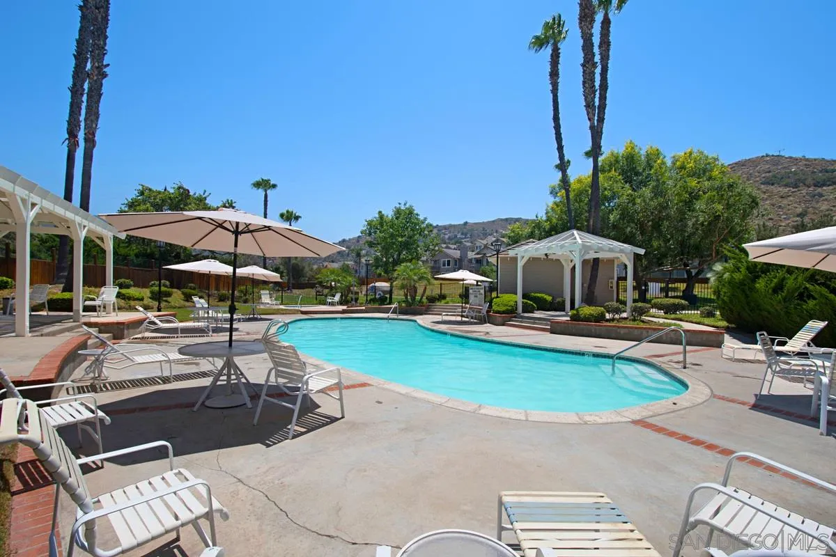 1237 Buttonwood Court El Cajon, CA 92019 - Photo 37 of 45 a view of a swimming pool with lawn chairs under an umbrella
