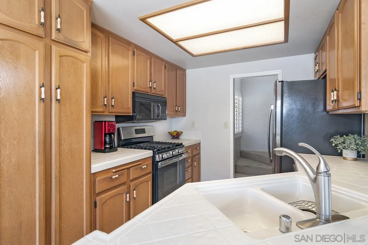 1237 Buttonwood Court El Cajon, CA 92019 - Photo 10 of 45 a kitchen with stainless steel appliances kitchen island granite countertop a refrigerator stove and sink