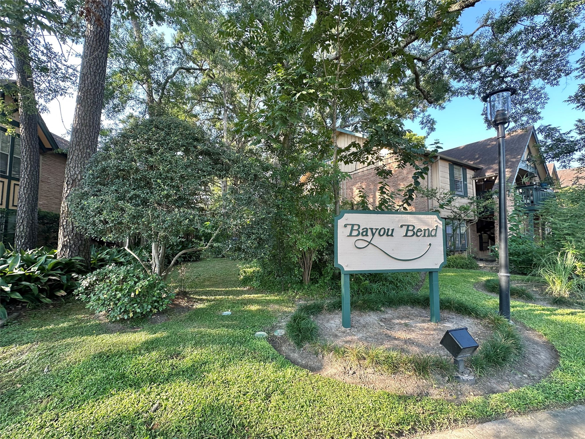 8245 Kingsbrook Road, Unit 236 Houston, TX 77024 - Photo 1 of 14 a view of a park that has a sign board large trees